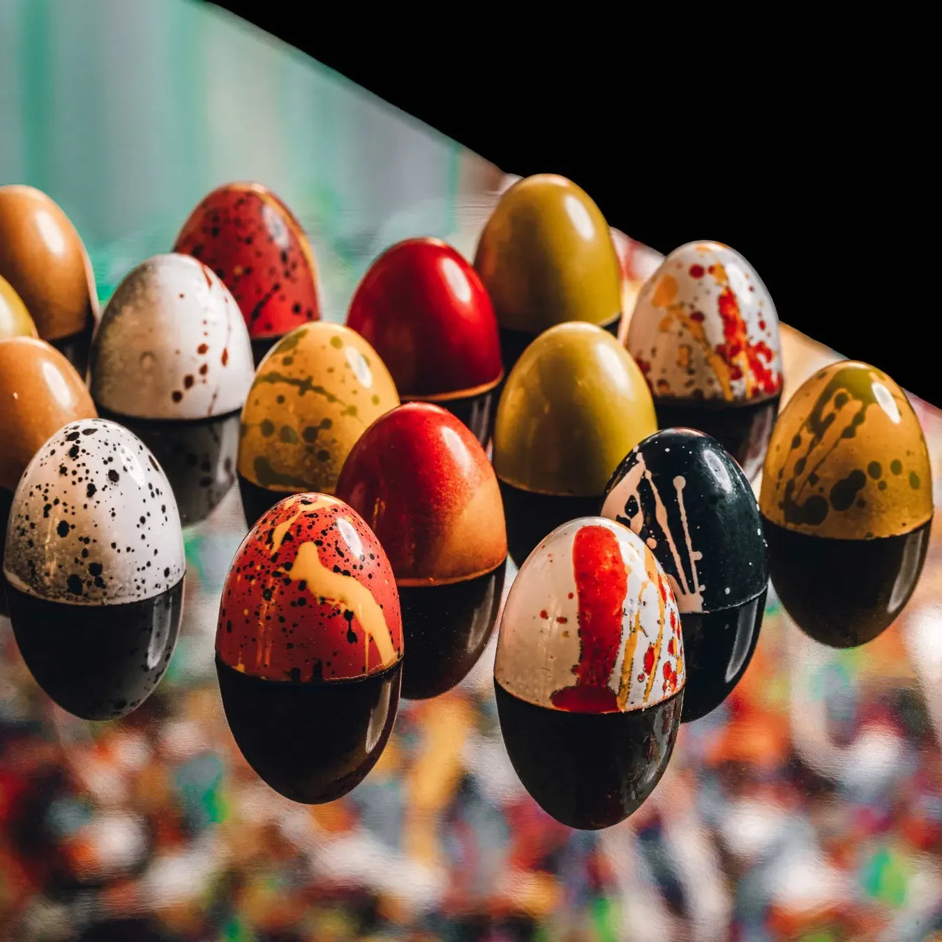 Colorful speckled eggs hanging against a blurred background