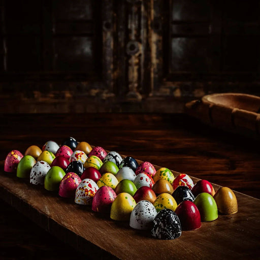 Assorted chocolate bonbons arranged on a wooden serving board for food service